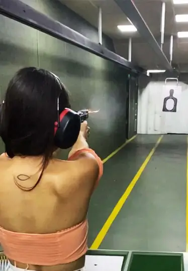 تیراندازی دختر مومشکی با تاپ صورتی کوتاه